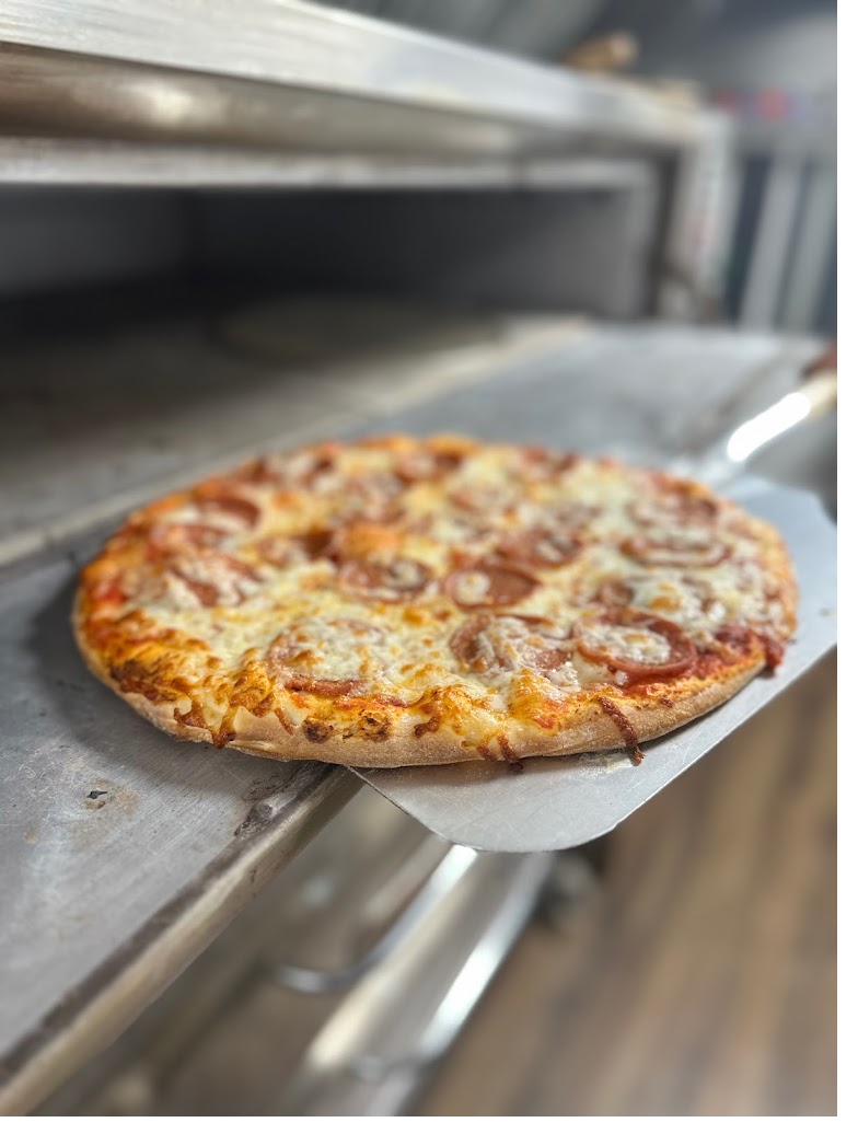Pepperoni pizza fresh out of the oven on a pizza peel